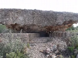 Vista exterior del búnquer con techo de roca y estructura de hormigón.