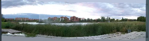 Panorámica del lago con edificios y vegetación.