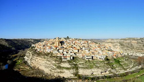 Vista de Jorquera en la cima de una colina con casas y un paisaje de fondo.