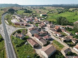Aerial view of a village with houses and a road in a rural environment.