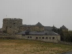 Schloss-Palast Magalia mit Steintürmen und Mauern an einem bewölkten Tag.