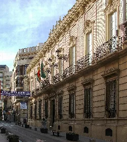 Facade of the Almería Provincial Council building with flags and decorative balconies.