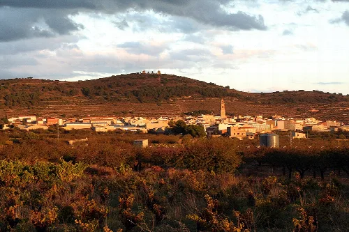 Panoramablick auf Alcublas mit Häusern, Kirche und Hügeln im Hintergrund.