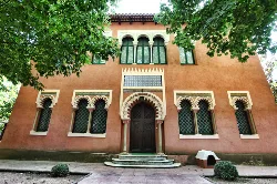 Facade of a tower with arched windows and a wooden door in Caldas de Malavella.
