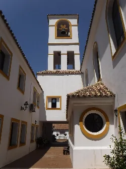 Church of el Rosario with tower and white and yellow facade in Benahavís.