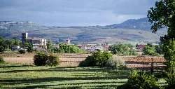 Vista panorámica de Sotresgudo desde el sur con campo y montañas al fondo.