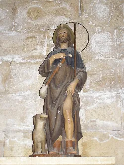 Statue von Heiligem Rochus mit Hund und Heiligenschein in einer Kirche in Cuenca.