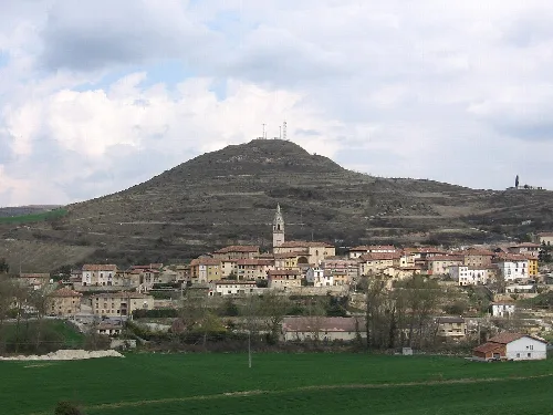 View of a village with hill and church in the foreground.