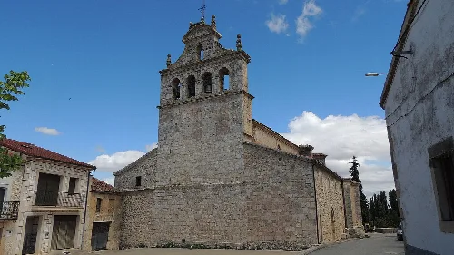 San Juan Bautista church in Urueñas with stone tower and facade.