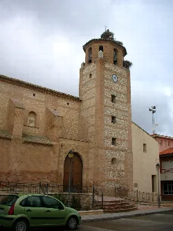 Torre de iglesia de Fréscano con nidos de cigüeñas y reloj en la fachada