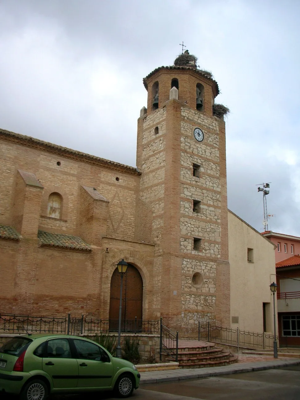 Torre de iglesia de Fréscano con nidos de cigüeñas y reloj en la fachada