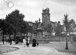 Square with fountain and trees in Durango, with Santa Maria church in the background.