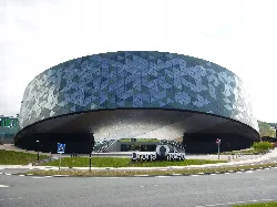 Modernes ovalförmiges Gebäude mit blauen und grauen Paneelen in Hernani.