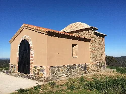 Kleine Kapelle mit Steinmauern, Eisentür und Kuppel in Valencia del Mombuey.