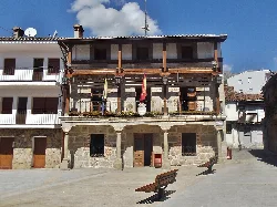 Town hall building with wooden balconies and flags on the facade.