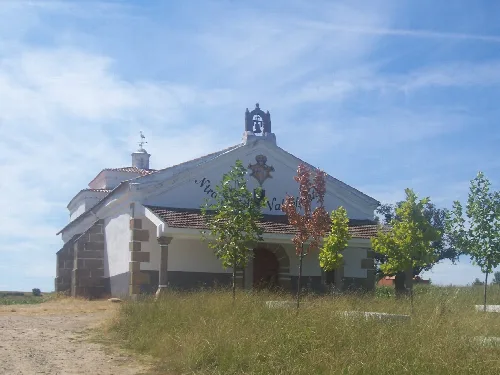 Kleine Kapelle mit Bäumen und blauem Himmel in Montehermoso.