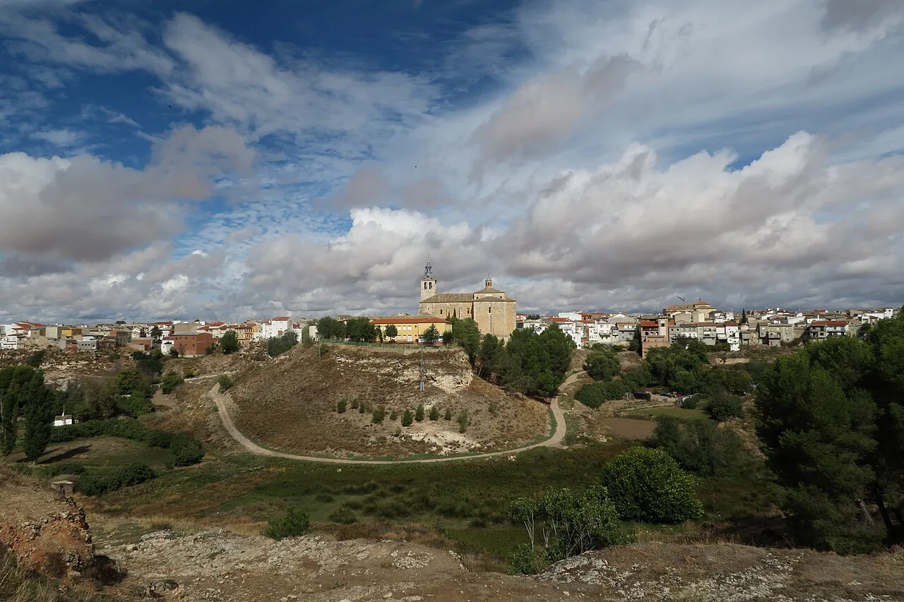 Landscape with town and church in Dosbarrios, Toledo, under a cloudy sky.