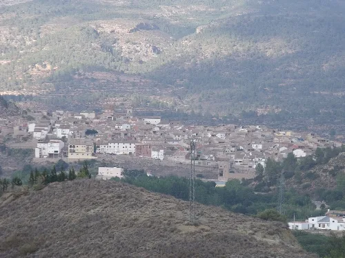 Blick auf eine Stadt mit weißen Häusern und Bergen im Hintergrund.