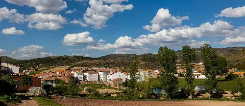 Panoramic view of Checa with white houses and green hills.
