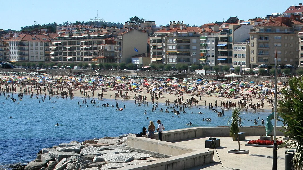 Playa del Silgar con gente en la arena y en el mar en Sanxenxo.