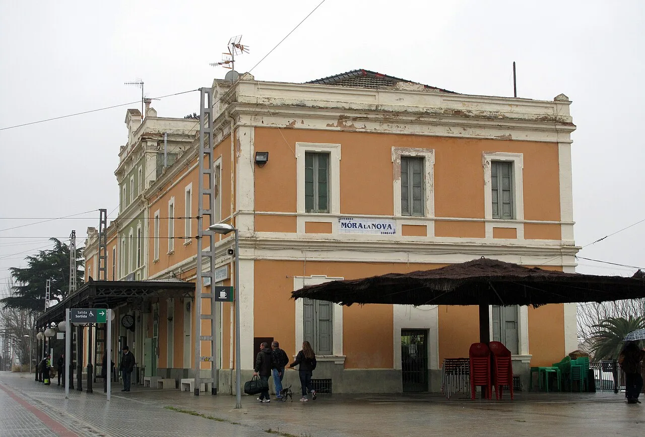 Bahnhof Móra la Nova mit Bahnsteigen und wartenden Personen.