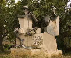 Sculpture of two farmers in Guadassuar, Valencia, with tropical plants.