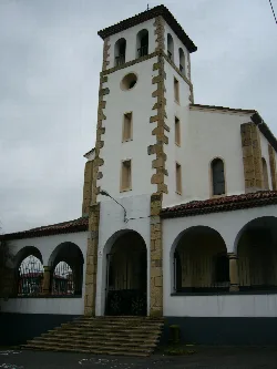 Torre de iglesia con ventanas y puerta en Corvera de Asturias.