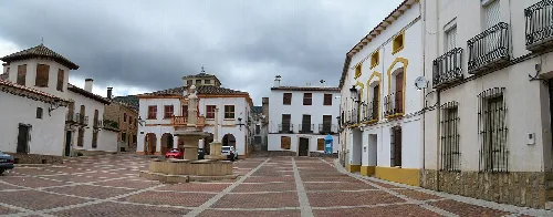 Plaza con fuente en el centro y edificios blancos en Bienservida.