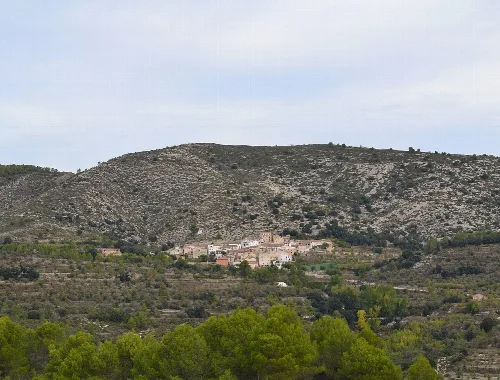 Landscape of Tollos with hills and greenery in the foreground.