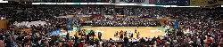 Inside the pavilion with players and audience during a basketball game.