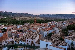 Vista de casas y una iglesia en Martín del Río, con montañas al fondo.