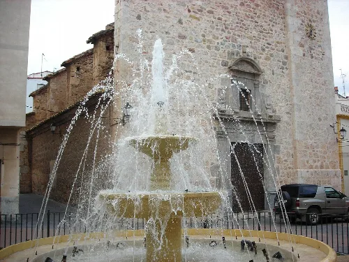 Fuente de piedra con agua en la plaza de Geldo.