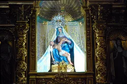 Statue of the Virgin of Sorrows in the chapel, with golden details and decorative background.