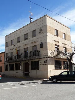 Town hall building with flag and clock in Fontanares.