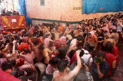 Personas cubiertas de tomate en una pelea en las calles de Buñol durante La Tomatina.