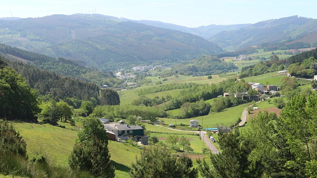 Vista panorámica de Riotorto con colinas verdes y casas en un entorno rural.