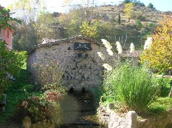 San Miguel Museum in Belorado mit Wandbild und Bach im Vordergrund.