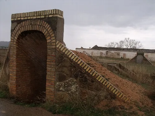 Backsteinbogen und Erdhügel am Eingang des Schutzraums
