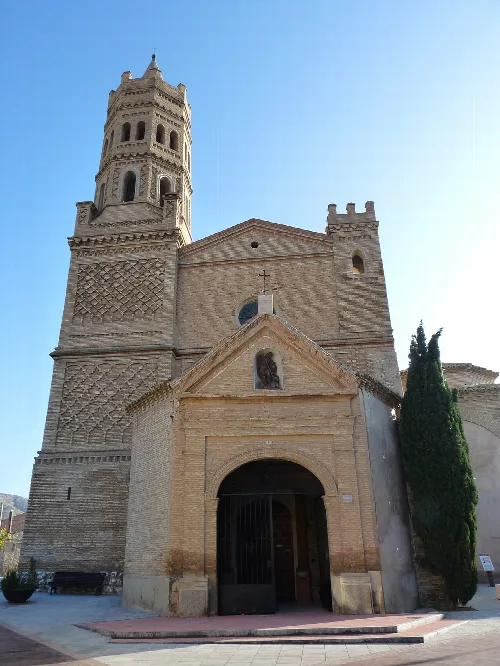 Facade of San Miguel Arcángel Church with Mudéjar tower in Alfajarín.