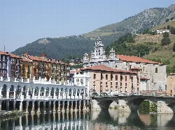Vista del río Oria con edificios y montañas en Tolosa.