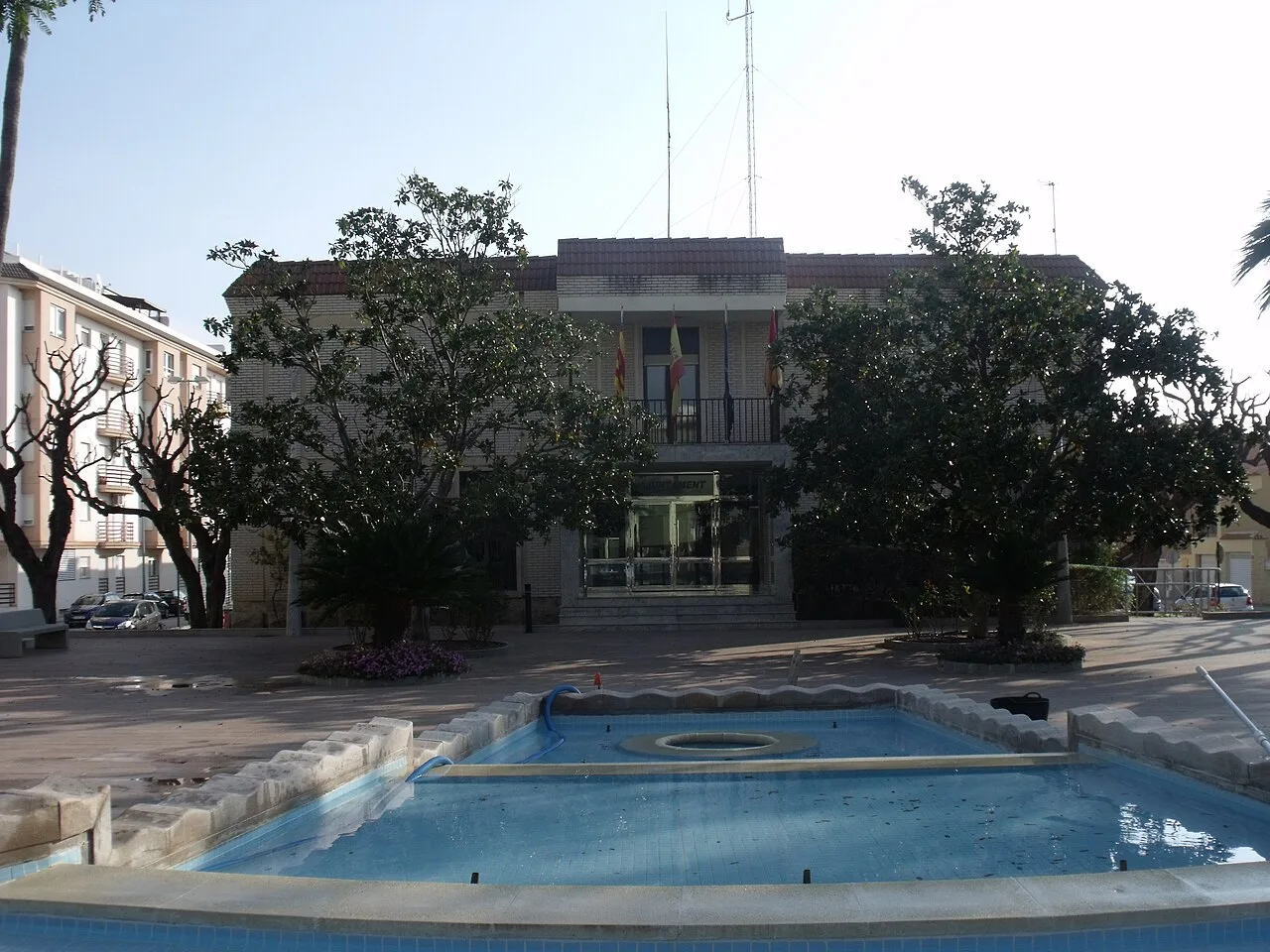 Edificio del ayuntamiento de Miramar con fuente y árboles en la plaza.