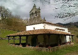 Sanctuary with tower and wooden structure in a rural landscape.