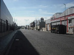 Zona industrial con edificios y contenedor de basura en Rafelbuñol.