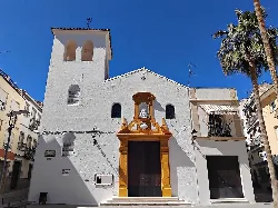 Facade of the Holy Spirit Chapel with wooden door and golden columns in Doña Mencía.