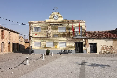 Rathausgebäude mit Uhr und Flaggen in Gomecello.