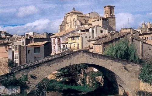 Steinbrücke mit Häusern und Kirche in Estella