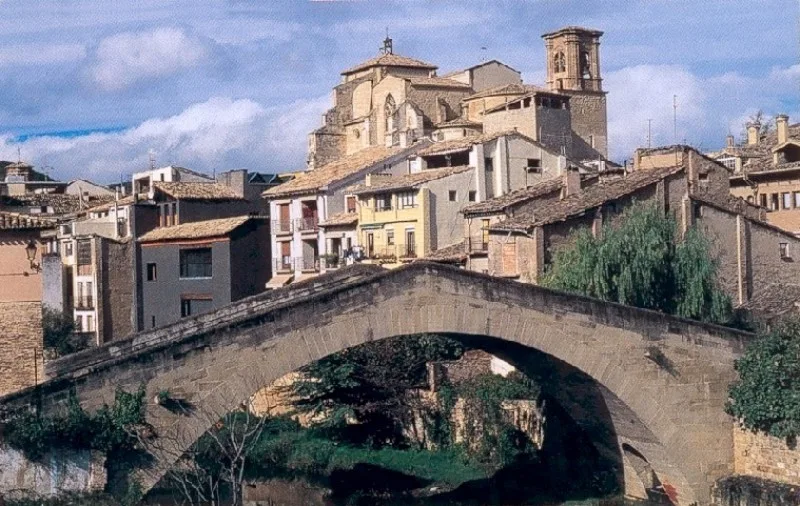 Stone bridge with houses and church in Estella