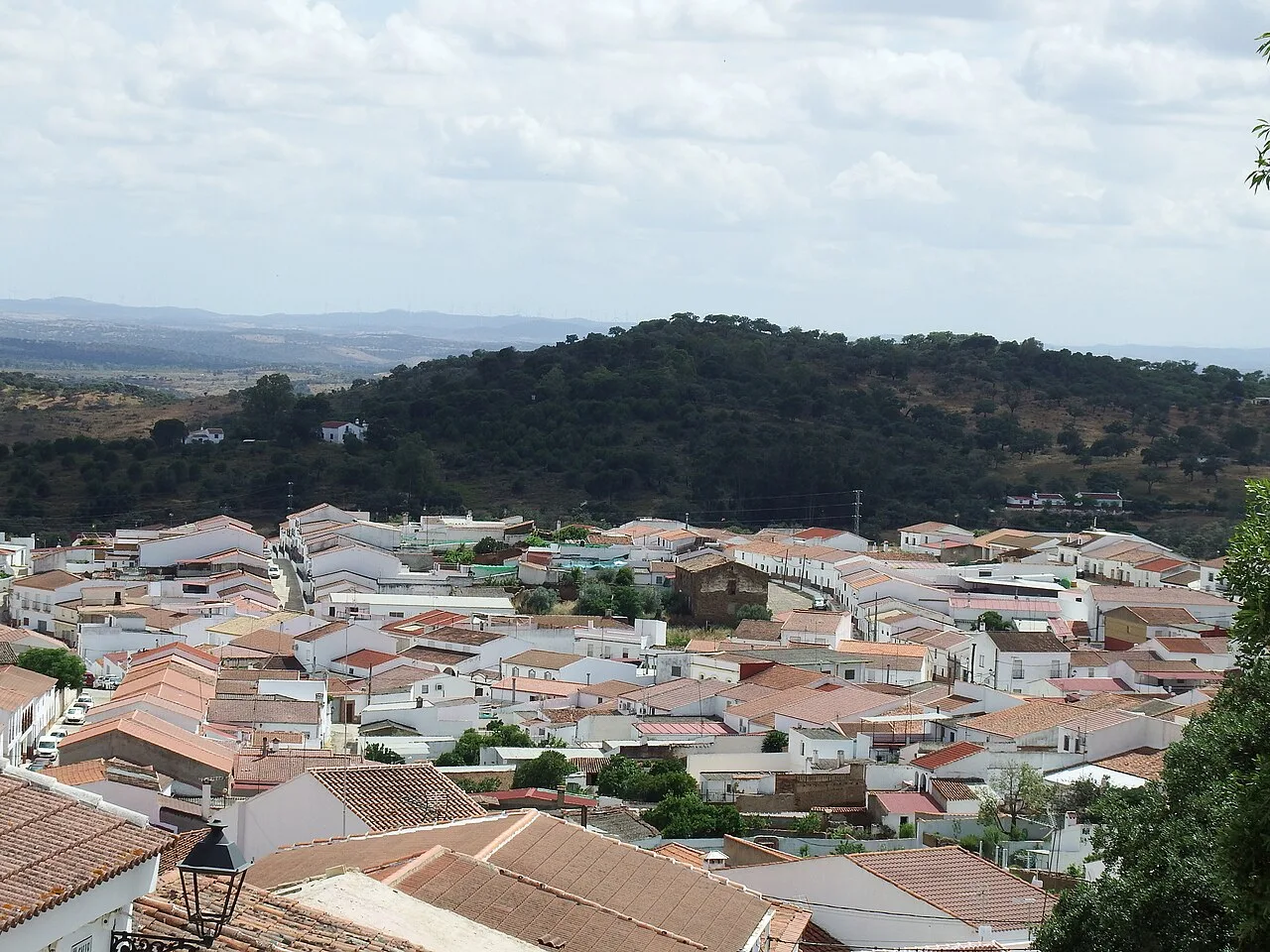 Houses with red-tiled roofs and green hills in Santa Bárbara de Casa.