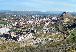 View of Monzón, with the castle on the hill and modern buildings in the valley.