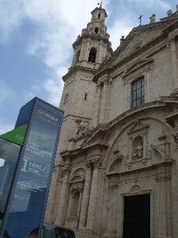 Facade of a church with tower and ornamental details in Cheste.